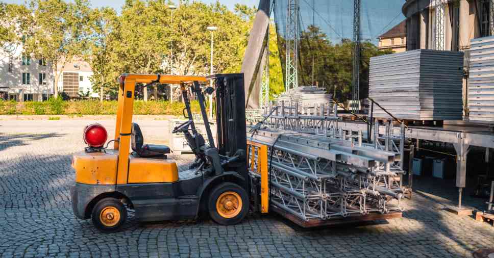 O pátio de montagem de palco usa empilhadeiras em feiras e eventos para movimentar estruturas.