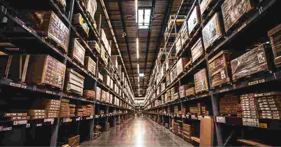 Prateleiras industriais altas e alinhadas para mostrar como organizar um armazém de grande porte.